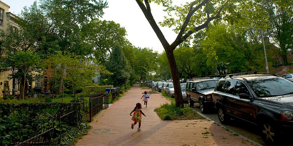 two young children run down the sidewalk