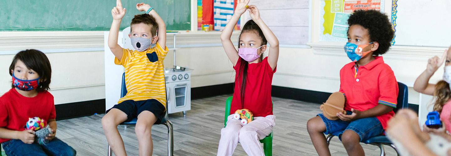 a group of young children in class wearing masks