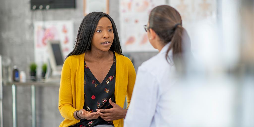 a young woman talks to her doctor