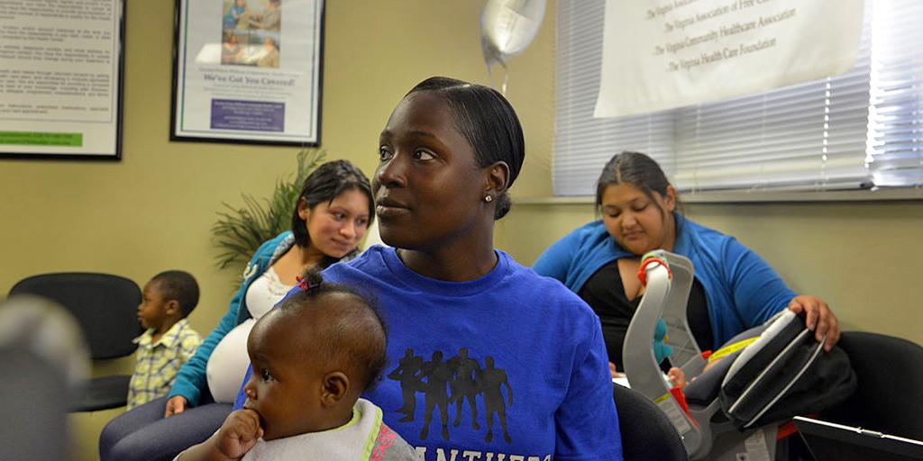 a mother holds her daughter at a health center
