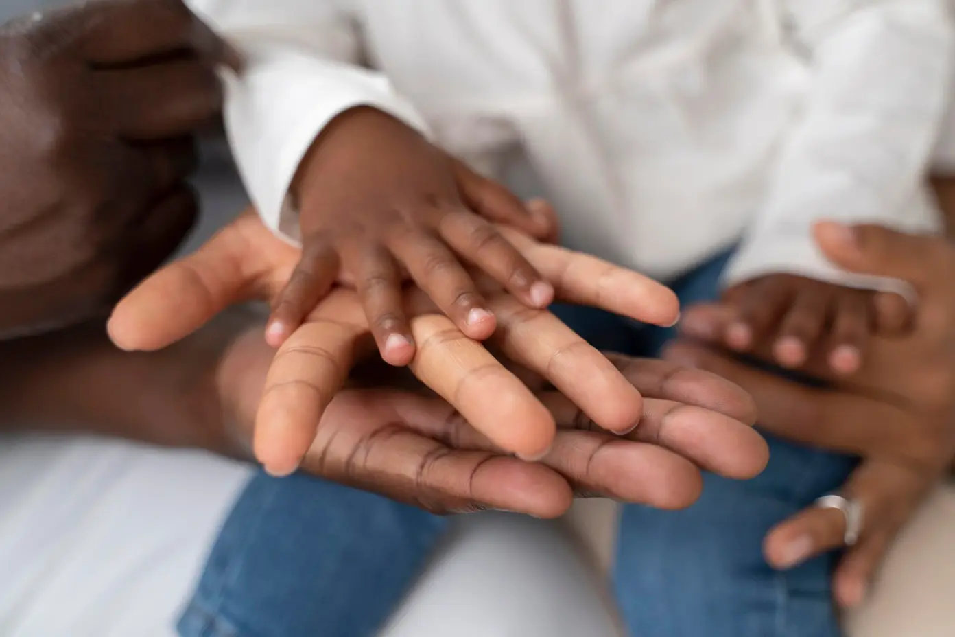 A child hands on top of adults' hands