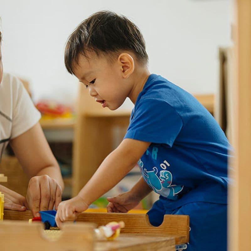 a young boy and his mom play with blocks