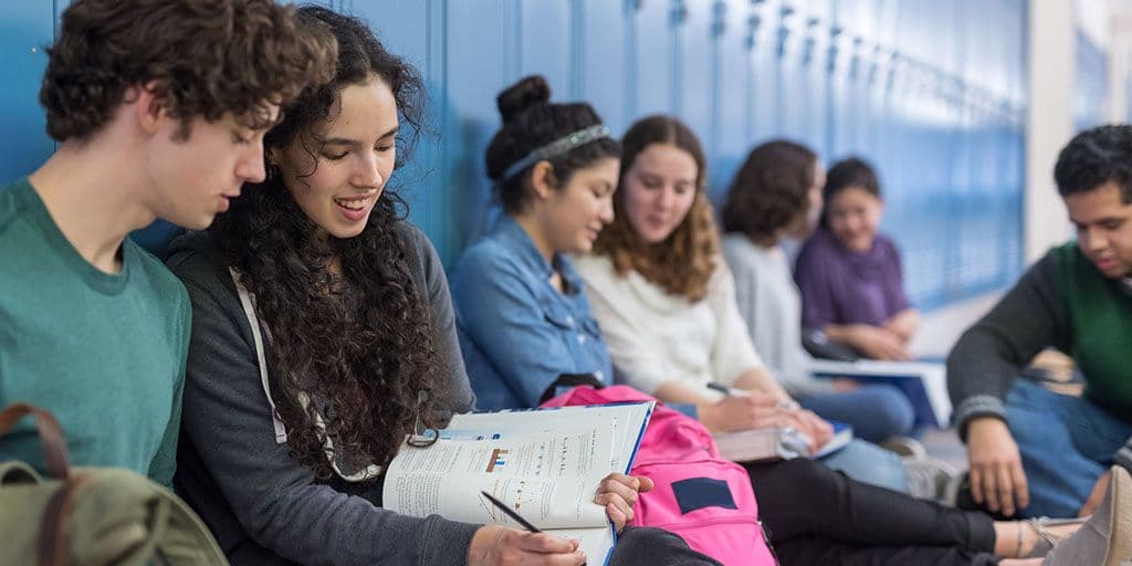 a group of high schoolers hang out by their lockers
