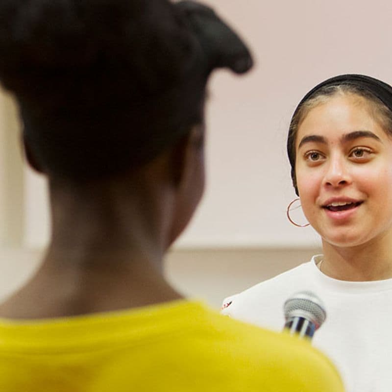 a young woman speaks to a peer